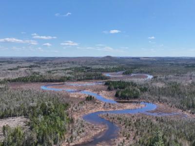 An aerial view of a river winding through a forest, a land return to Mi'kmaq Nation