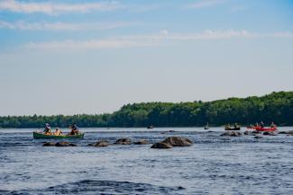 People in canoes, paddling down a river