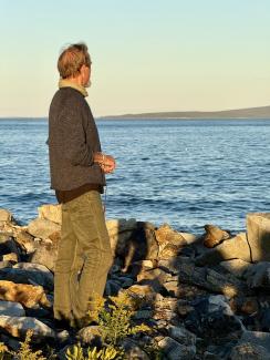 man stands by coast looking at horizon